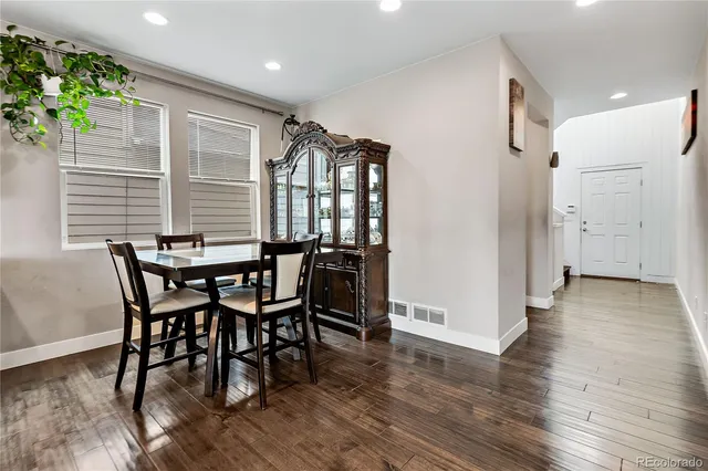a dining room with furniture and wooden floor