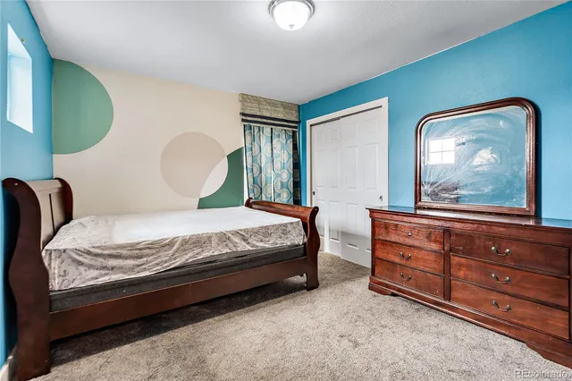 a bedroom with a bed and dresser with mirror