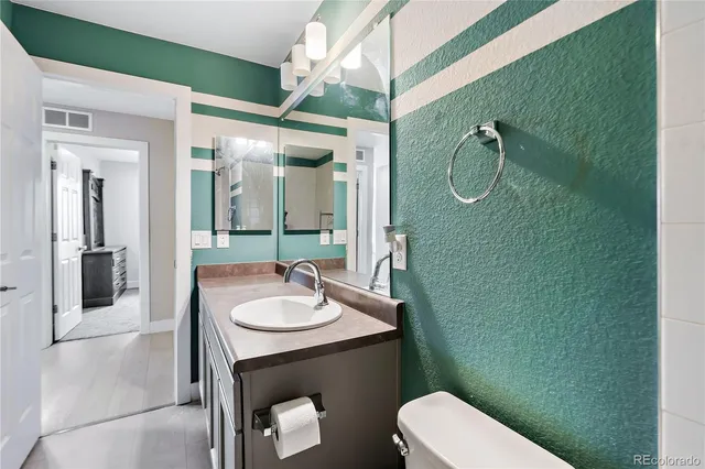 a bathroom with a sink a toilet and mirror