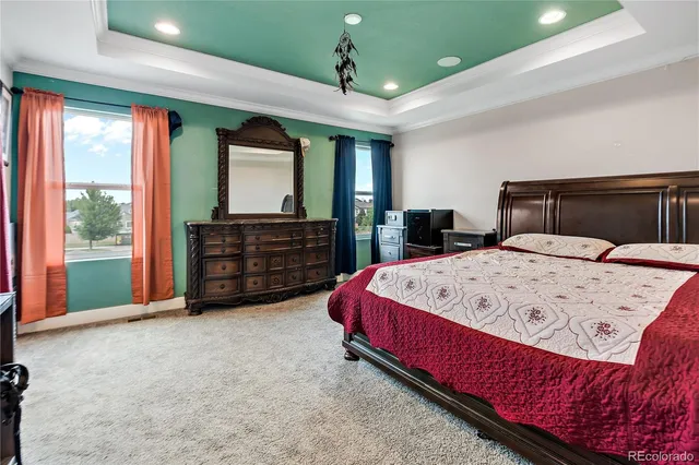 a bed sitting in a spacious bedroom next to a window