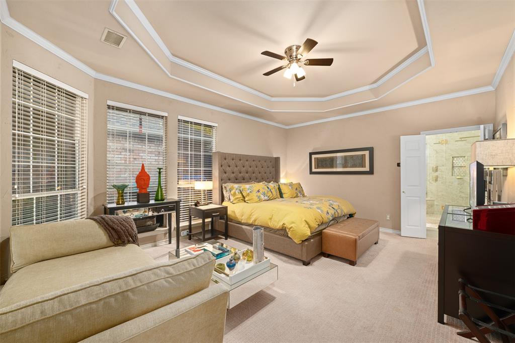 17608 Windflower Way Dallas, TX 75252 - Photo 15 of 34 Carpeted bedroom with a tray ceiling, ceiling fan, ornamental molding, and ensuite bath