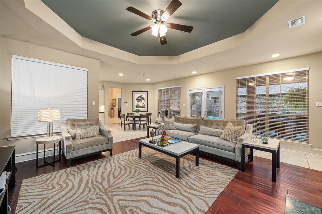 17608 Windflower Way Dallas, TX 75252 - Photo 19 of 34 Living room featuring a tray ceiling, wood finished floors, ceiling fan, and recessed lighting
