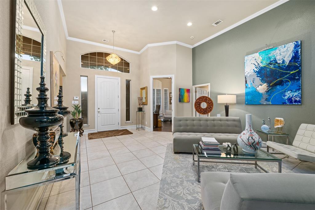 17608 Windflower Way Dallas, TX 75252 - Photo 6 of 34 Living room featuring crown molding, a towering ceiling, light tile patterned floors, and recessed lighting