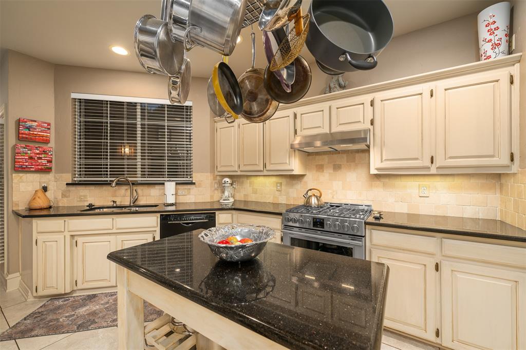 17608 Windflower Way Dallas, TX 75252 - Photo 9 of 34 Kitchen with dark stone countertops, stainless steel gas stove, decorative backsplash, cream cabinets, and recessed lighting