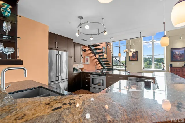 a kitchen with stainless steel appliances kitchen island granite countertop a stove and refrigerator