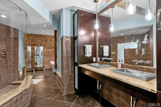 a bathroom with a granite countertop sink a large mirror and a shower