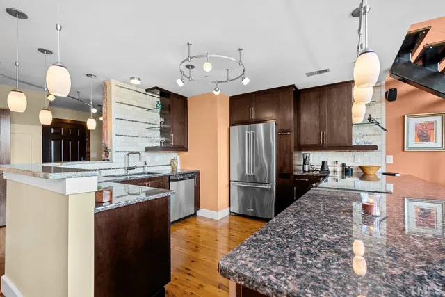 a kitchen with granite countertop a stove refrigerator and cabinets