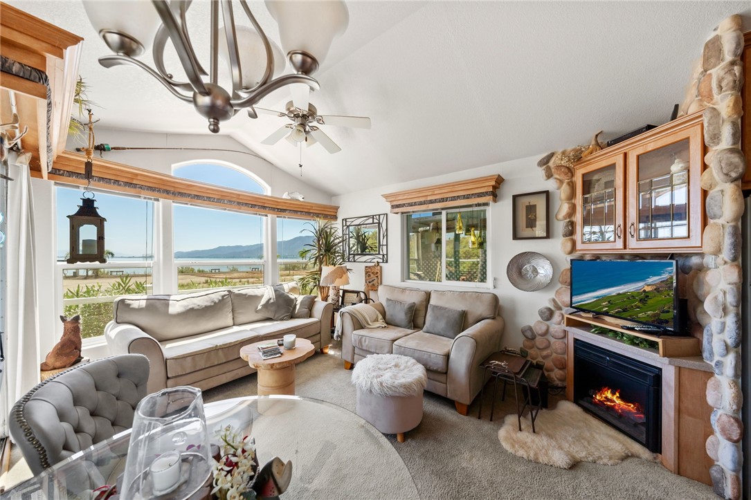 32000 Riverside Drive, Unit J8 Lake Elsinore, CA 92530 - Photo 16 of 33 a living room with furniture a fireplace and a floor to ceiling window