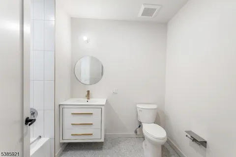 a bathroom with a sink toilet and a mirror