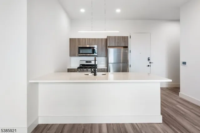 a kitchen with kitchen island a sink appliances and cabinets