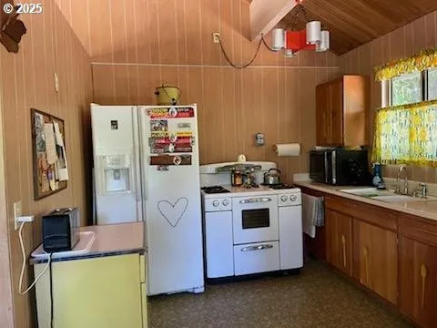 a kitchen with stainless steel appliances a stove refrigerator and sink