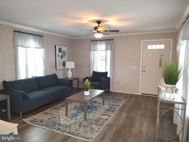a living room with furniture a chandelier and wooden floor