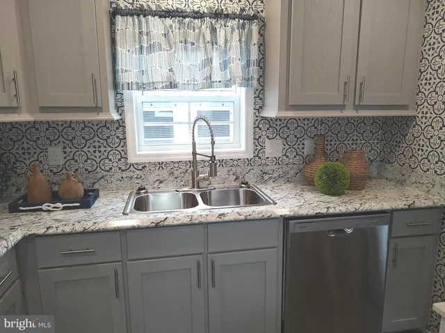 a kitchen with stainless steel appliances granite countertop a sink a stove and cabinets