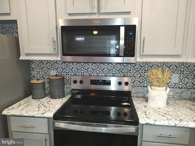 a kitchen with granite countertop a stove and a sink