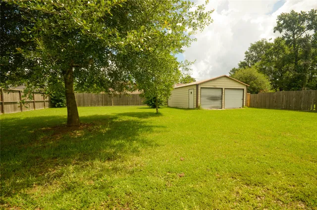 a view of a house with a big yard and large trees