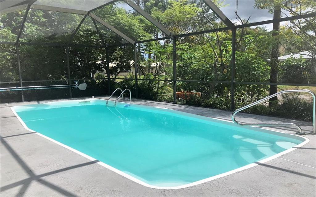 3850 Southeast Middle Street Stuart, FL 34997 - Photo 2 of 11 a view of a swimming pool with a patio and a yard