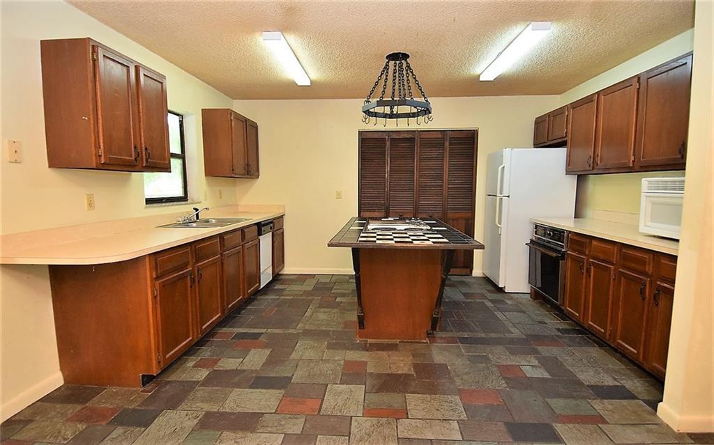 3850 Southeast Middle Street Stuart, FL 34997 - Photo 7 of 11 a kitchen with stainless steel appliances a sink wooden cabinets and counter space