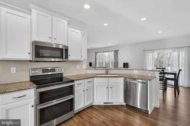 a kitchen with appliances a sink and cabinets