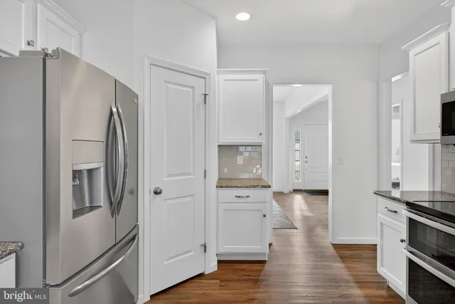 a view of kitchen with stainless steel appliances refrigerator stove microwave and cabinets