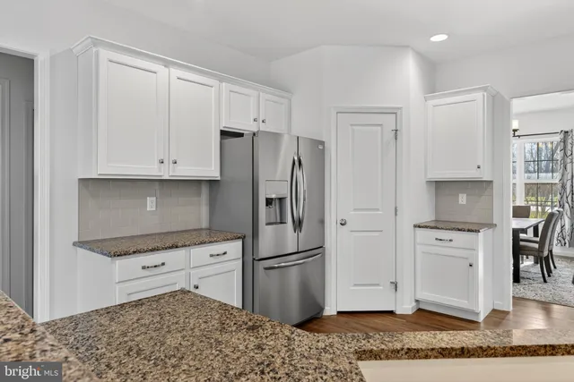 a kitchen with stainless steel appliances granite countertop a refrigerator and a stove top oven