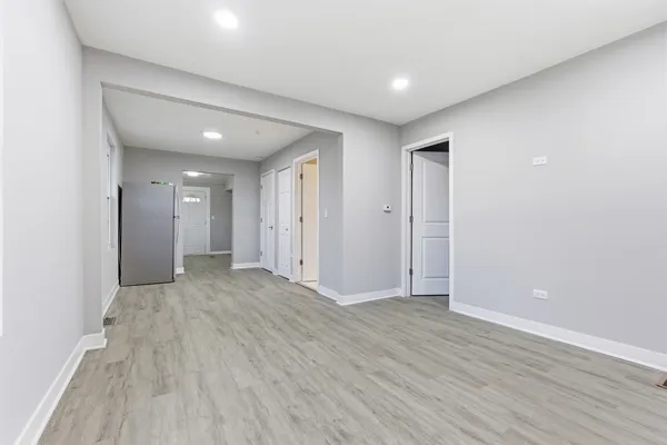 an empty room with wooden floor & windows