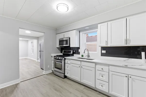 a kitchen with white cabinets sink and stainless steel appliances