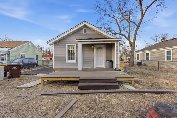 a front view of a house with cars parked