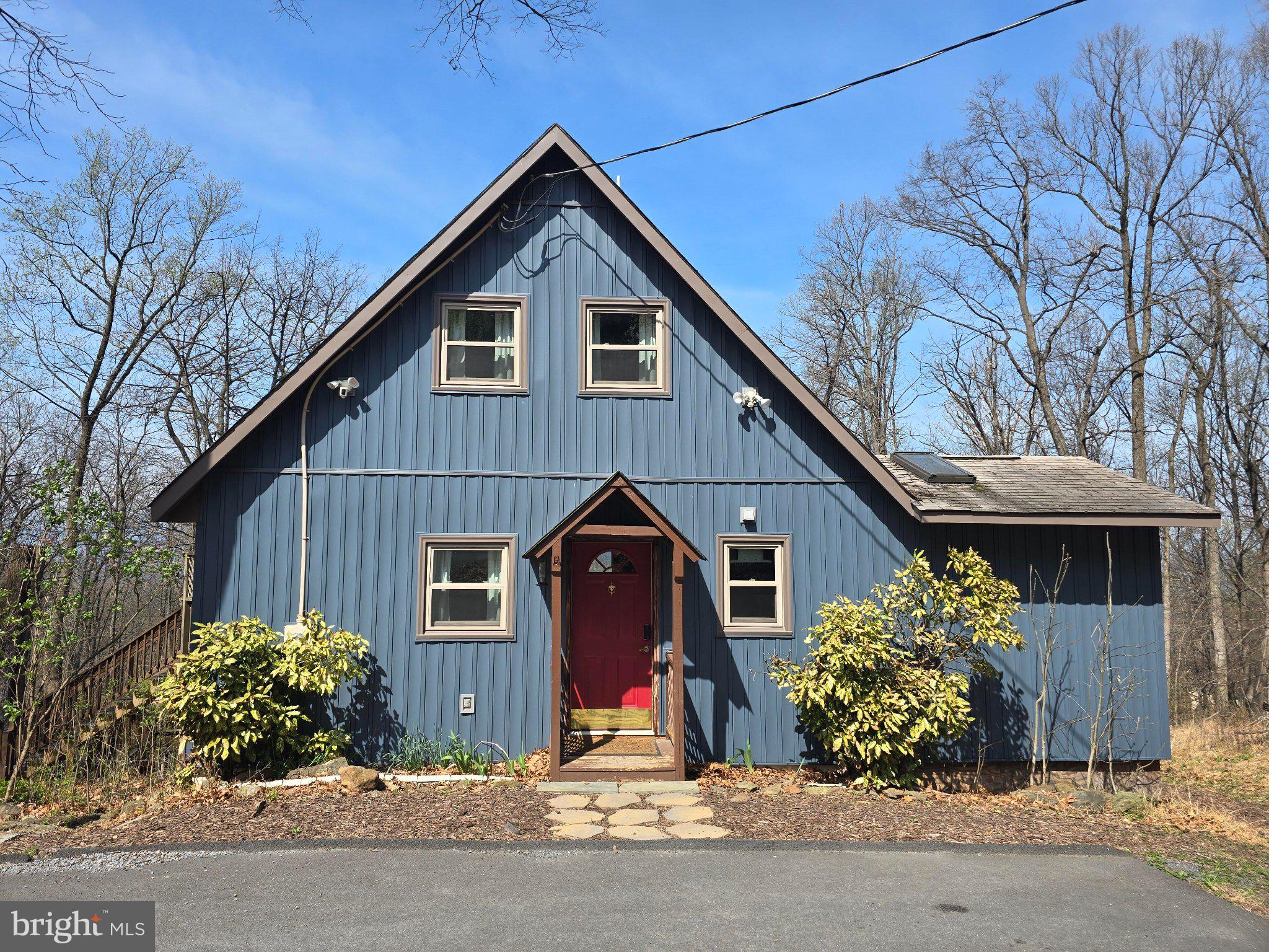 Charming blue cottage in nature's embrace.