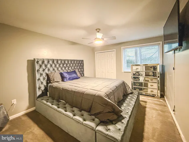 a spacious bedroom with a bed and a flat screen tv