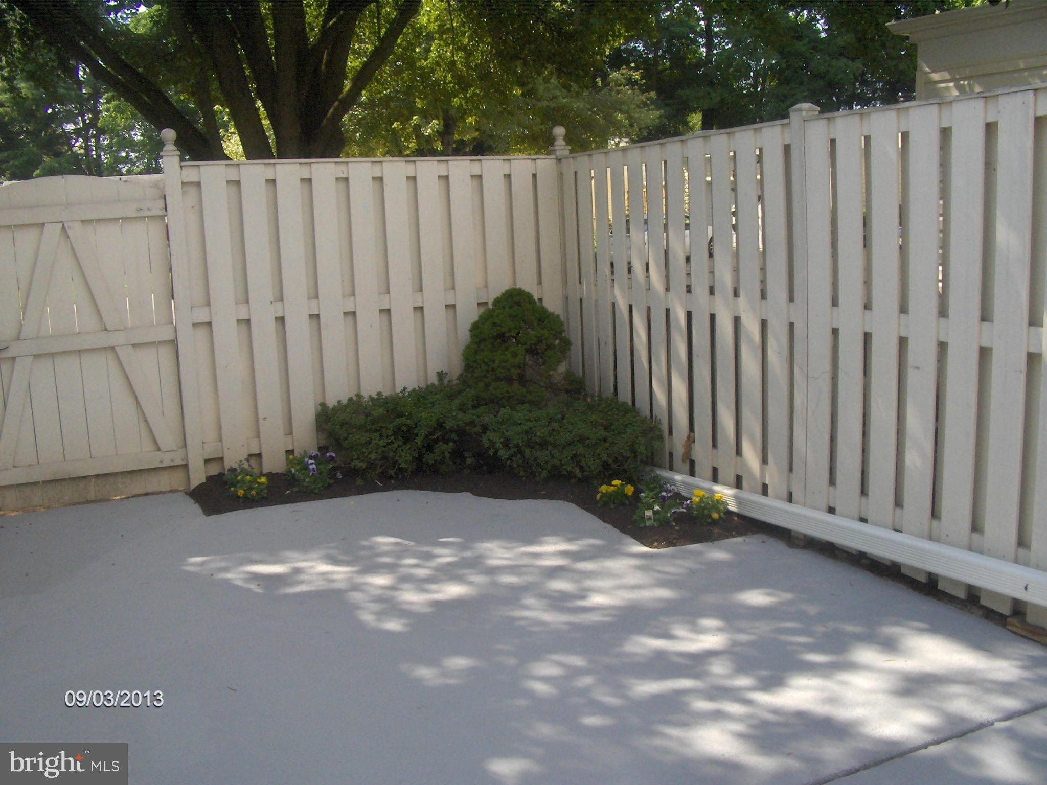 14502 Fiske Drive, Unit 138B Silver Spring, MD 20906 - Photo 15 of 21 a view of a pathway in a yard with wooden fence