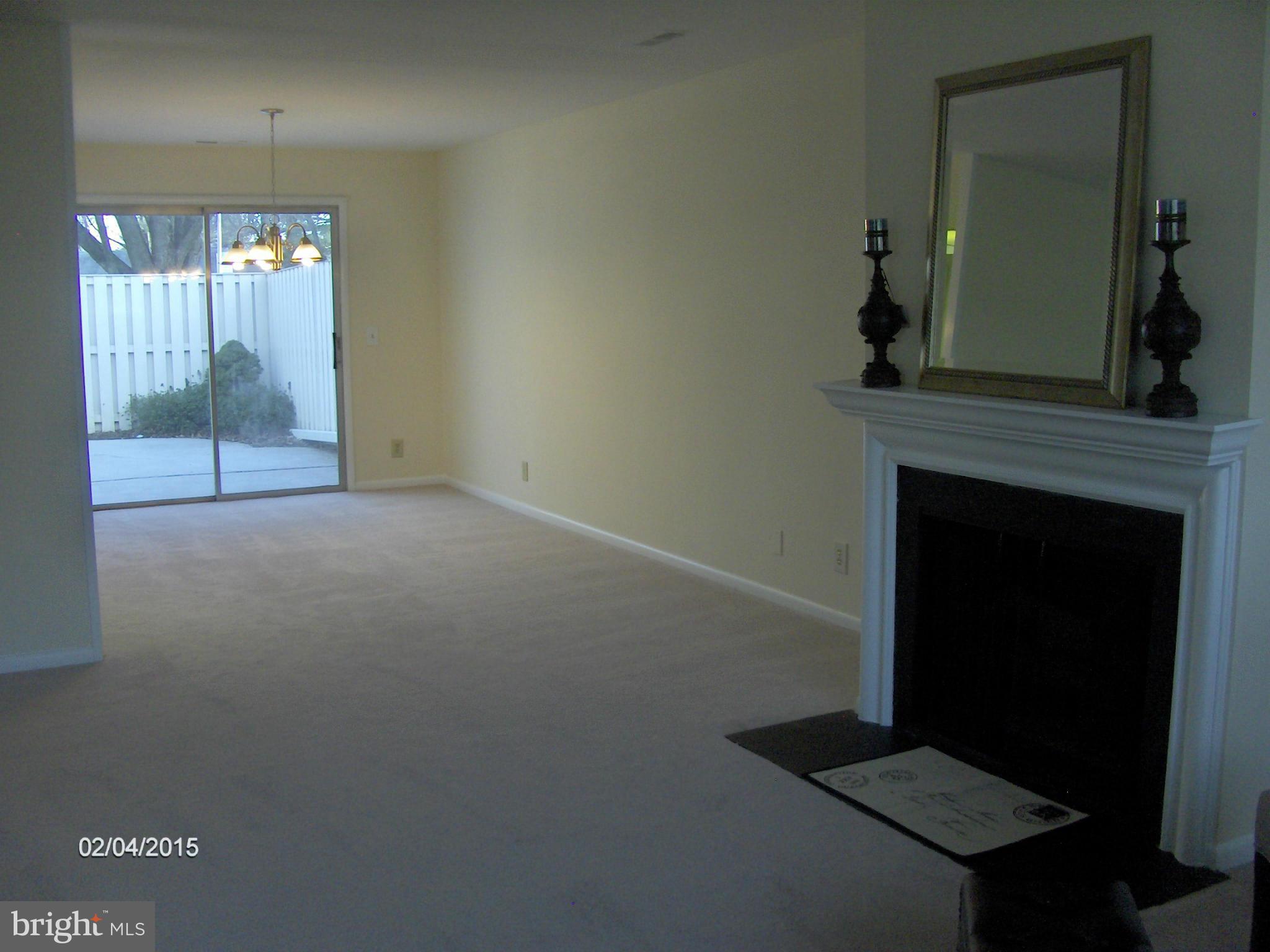 14502 Fiske Drive, Unit 138B Silver Spring, MD 20906 - Photo 7 of 21 a view of an empty room with wooden floor and a fireplace