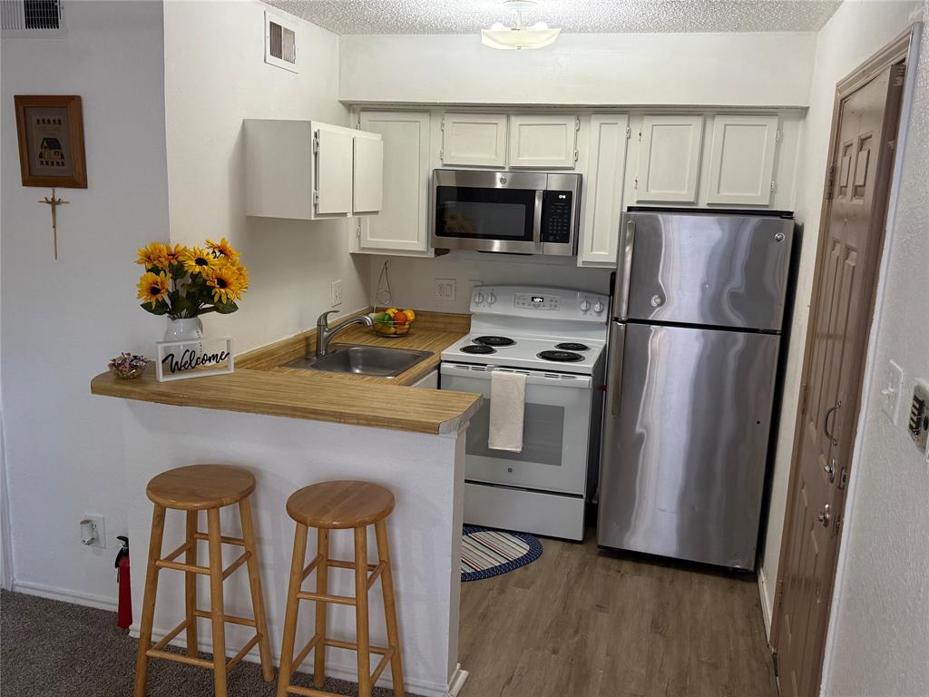 a kitchen with stainless steel appliances a refrigerator stove microwave and sink