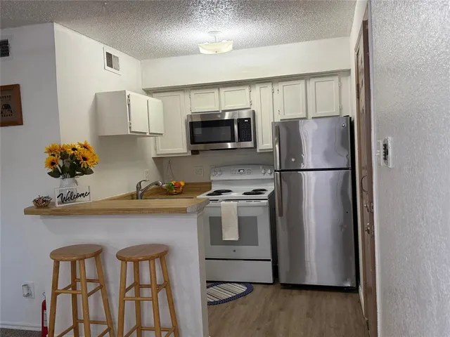 a kitchen with stainless steel appliances a refrigerator stove microwave and sink