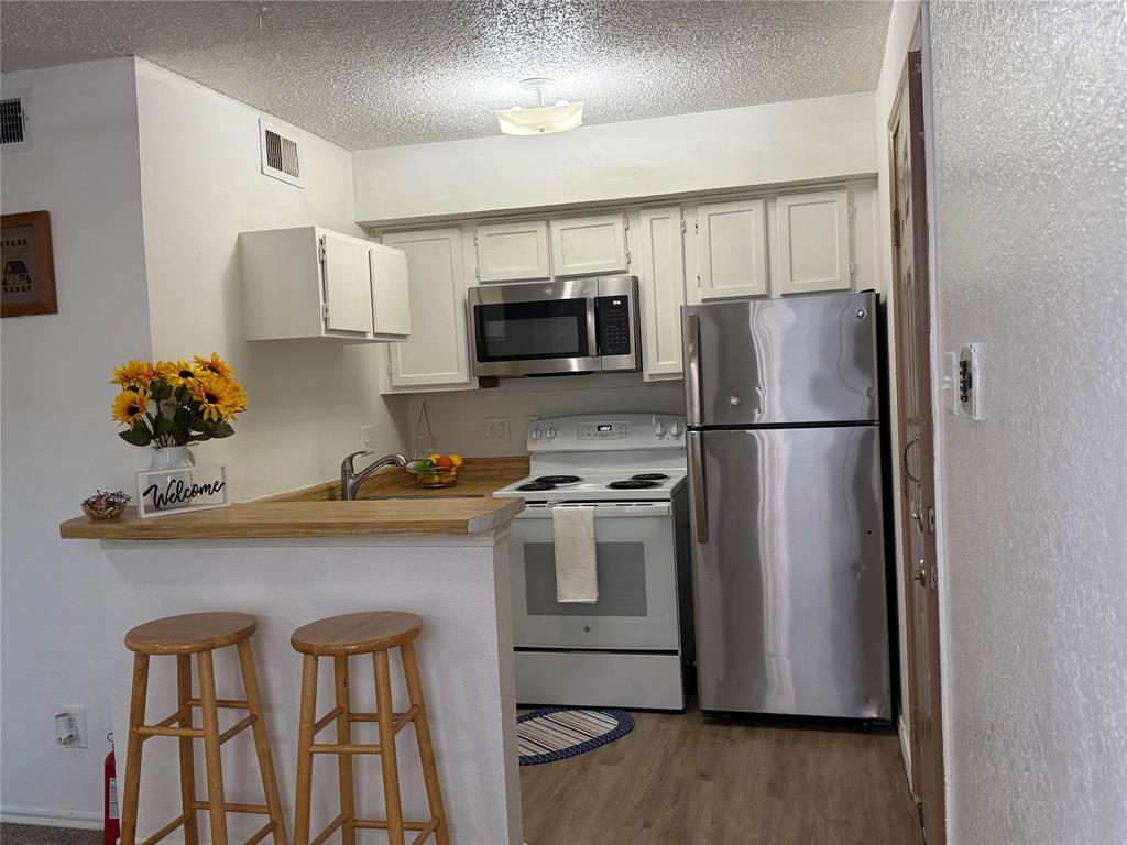 9803 Walnut Street, Unit 308 Dallas, TX 75243 - Photo 11 of 22 a kitchen with stainless steel appliances a refrigerator stove microwave and sink