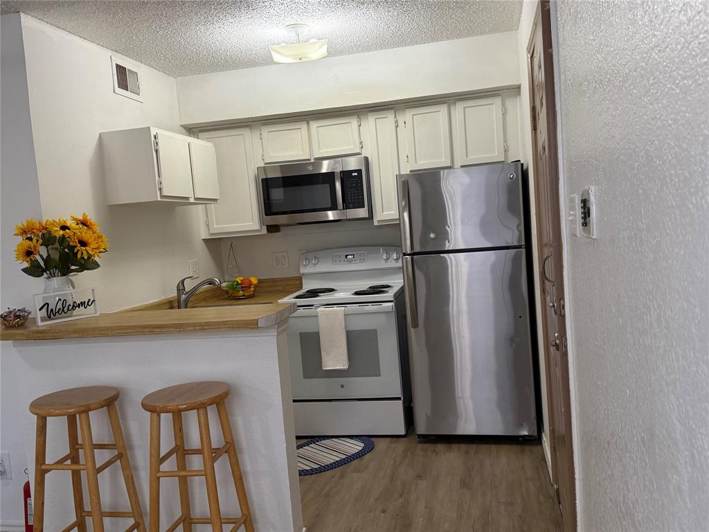 9803 Walnut Street, Unit 308 Dallas, TX 75243 - Photo 12 of 22 a kitchen with stainless steel appliances granite countertop a refrigerator sink and microwave