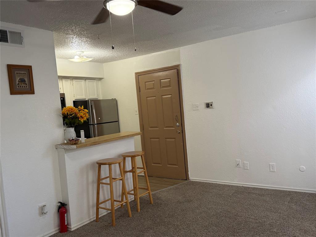 9803 Walnut Street, Unit 308 Dallas, TX 75243 - Photo 16 of 22 a living room with a table and a chandelier