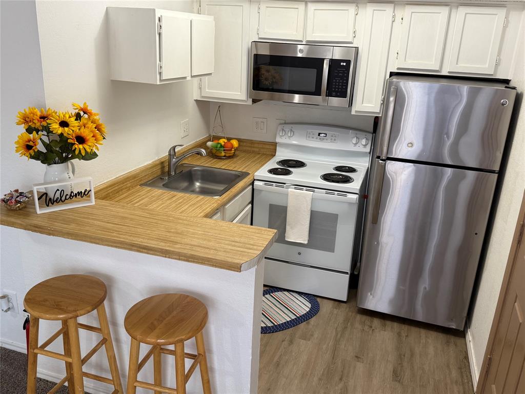 9803 Walnut Street, Unit 308 Dallas, TX 75243 - Photo 2 of 22 a kitchen with stainless steel appliances a stove a microwave and a refrigerator