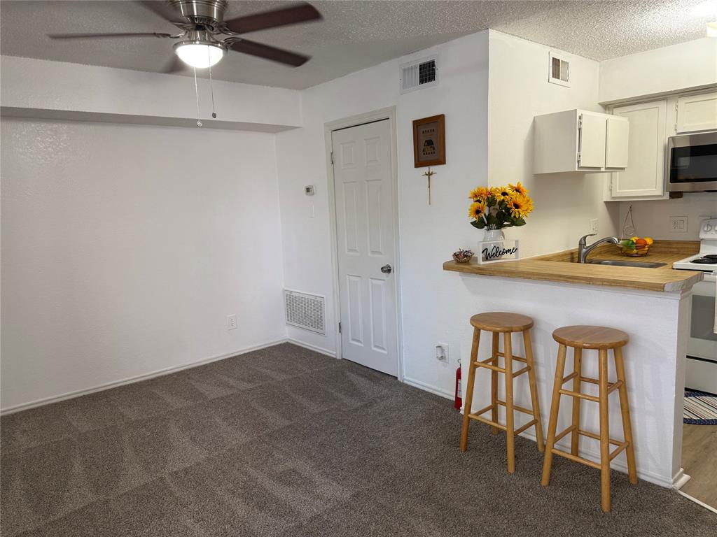 9803 Walnut Street, Unit 308 Dallas, TX 75243 - Photo 21 of 22 a kitchen with stainless steel appliances granite countertop a sink and cabinets