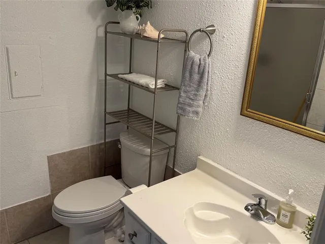 a bathroom with a toilet sink and mirror