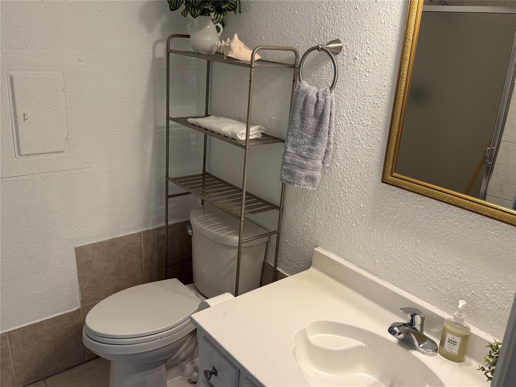 9803 Walnut Street, Unit 308 Dallas, TX 75243 - Photo 7 of 22 a bathroom with a toilet sink and mirror