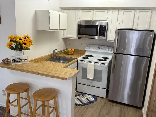 a kitchen with stainless steel appliances a stove a microwave and a refrigerator