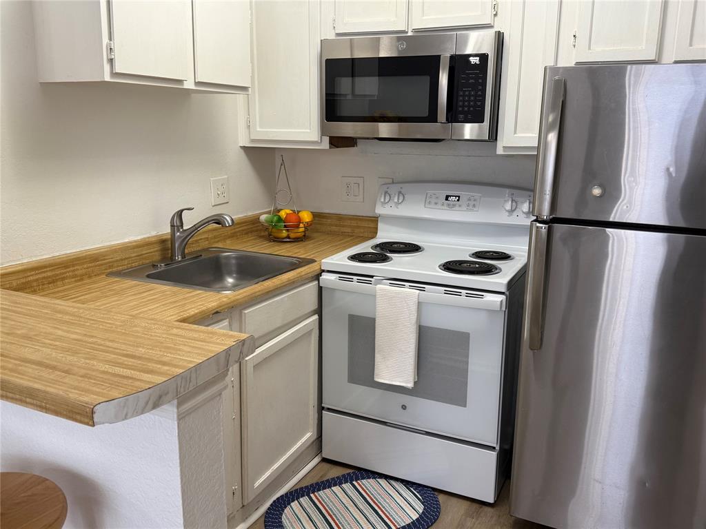 9803 Walnut Street, Unit 308 Dallas, TX 75243 - Photo 10 of 22 a kitchen with a stove microwave and refrigerator