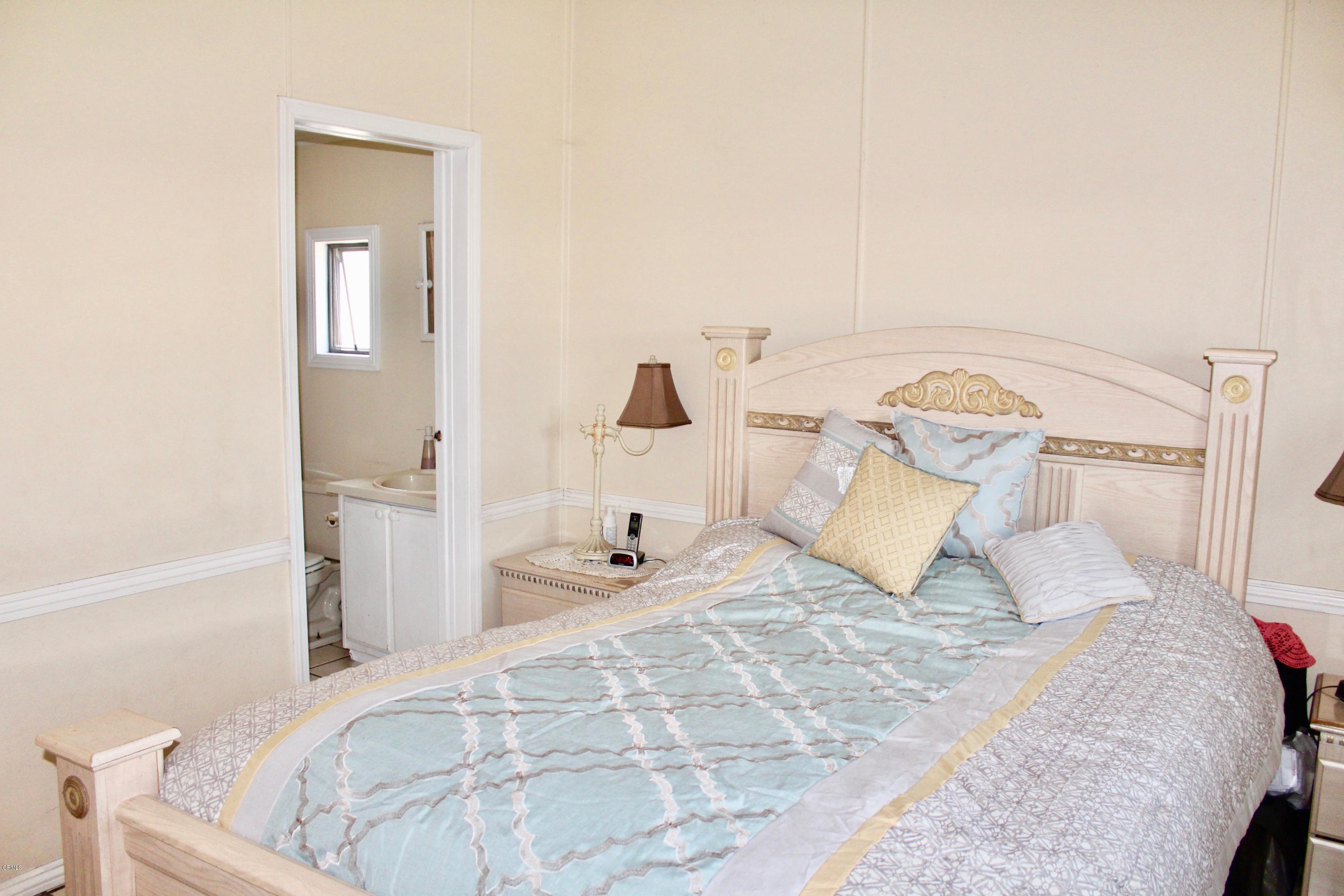 4145 Serena Lane, Unit 21 Oxnard, CA 93033 - Photo 8 of 16 a bedroom with a bed and a mirror