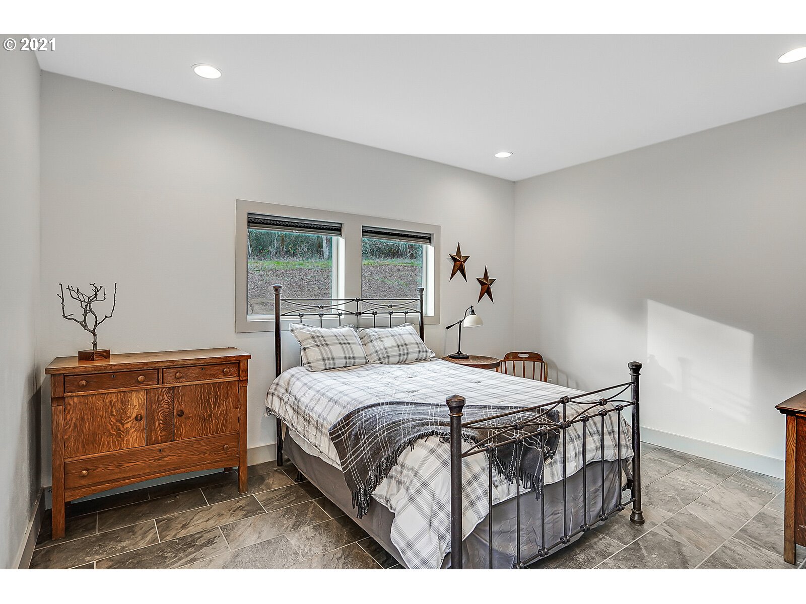22280 Pittman Road Sheridan, OR 97378 - Photo 23 of 32 a bedroom with a bed a dresser and potted plants