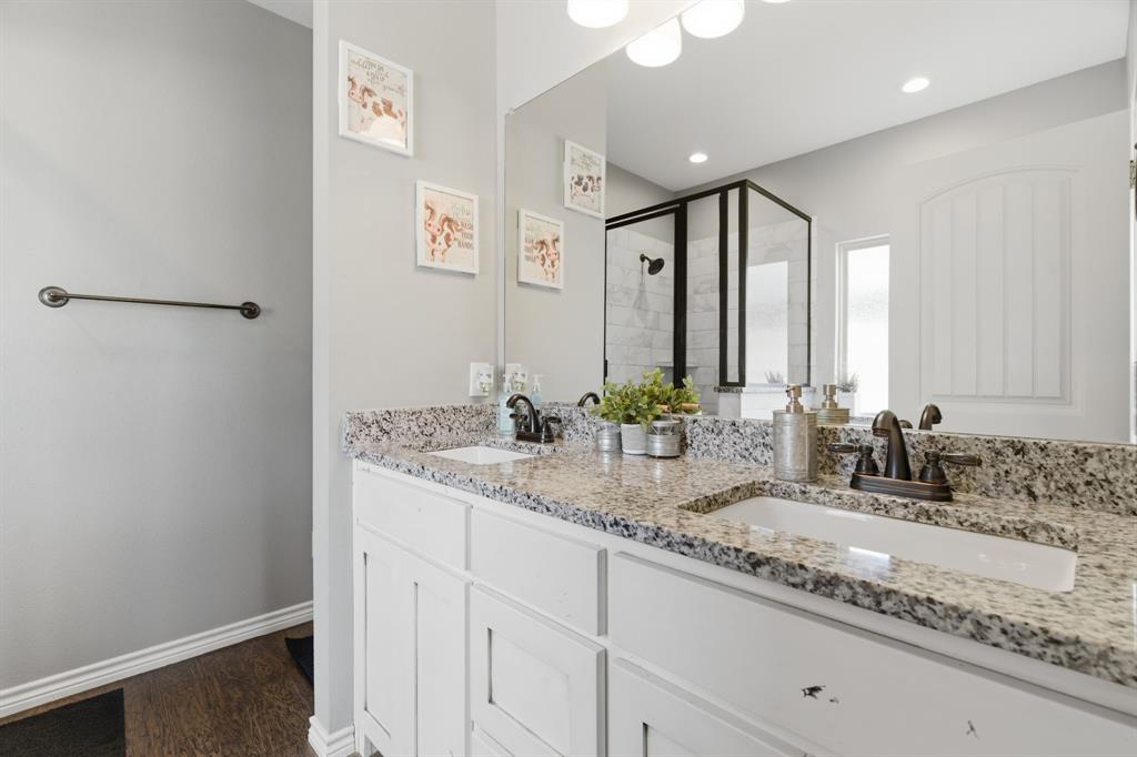 711 Hadley Lane Valley View, TX 76272 - Photo 21 of 40 Bathroom with a stall shower, double vanity, and dark wood finished floors