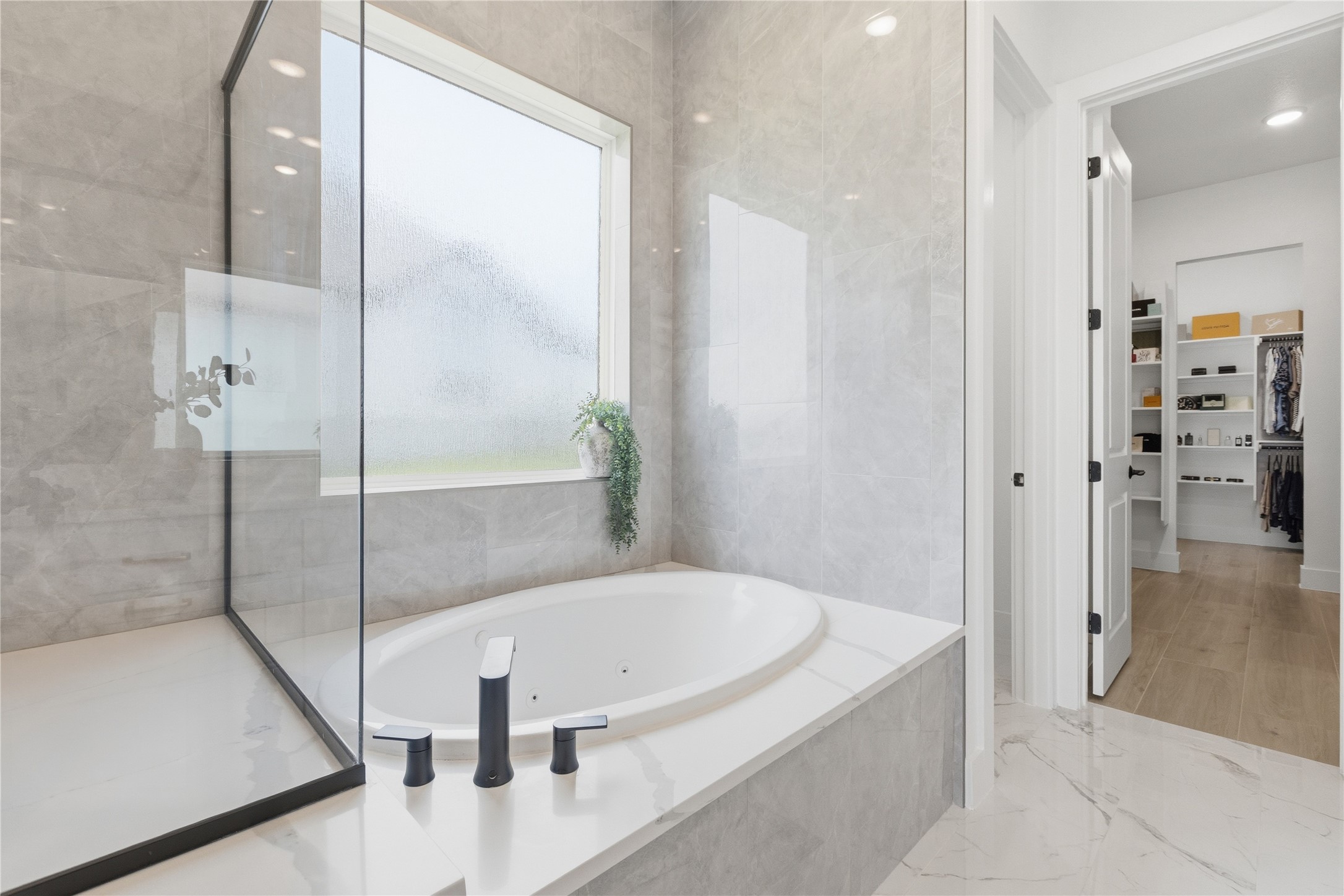 836 Villa Rialto View Leander, TX 78641 - Photo 17 of 33 Indulge in a relaxing soak within this primary bathroom's oversized tub, conveniently located near a spacious walk-in closet.