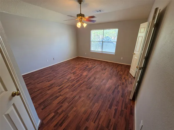 an empty room with a window and a fan