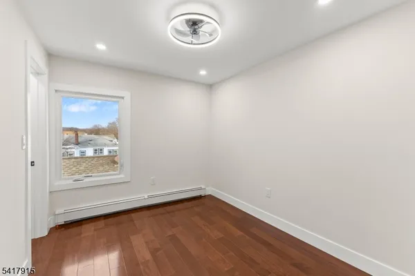 an empty room with wooden floor and a window