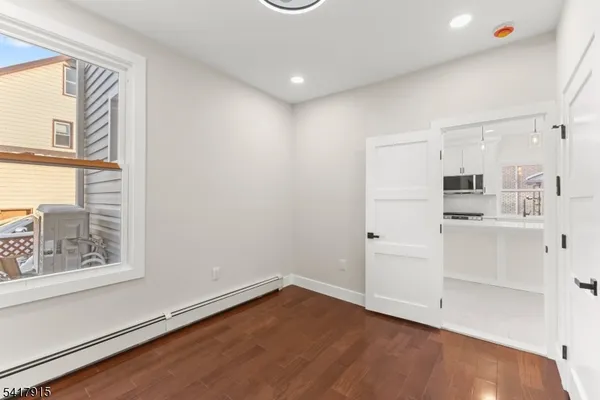 a view of kitchen with wooden floor and electronic appliances