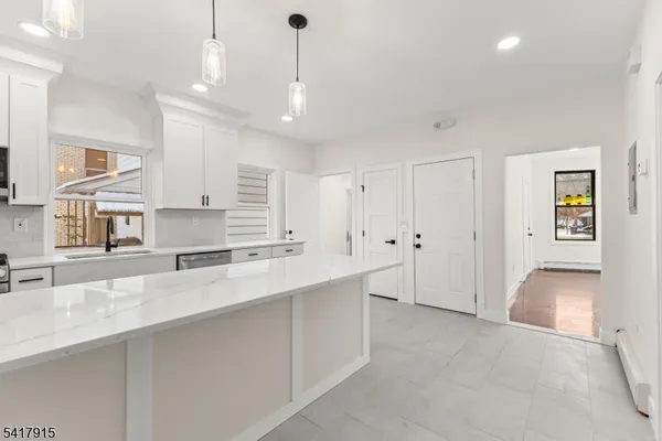 a kitchen with white cabinets appliances and a sink
